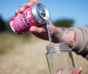 person pouring hip hop soda into a glass