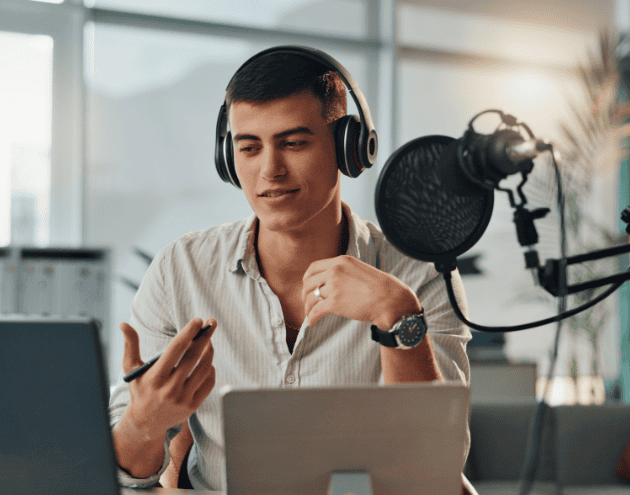 Person looking at laptop talking into a microphone
